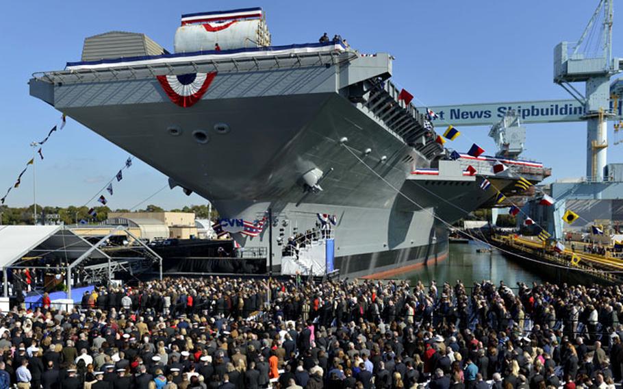 Servicemembers and distinguished guests bow their heads as Navy Capt. Jerome Hinson gives a benediction during the Gerald R. Ford's christening ceremony last November in Virginia. A General Accountability Office study released Nov. 20, 2014, states that the aircraft carrier will likely be incomplete and require more spending after its planned 2016 delivery to the Navy.
