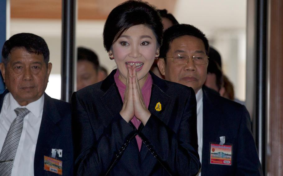 Thailand's former Prime Minister Yingluck Shinawatra, center, arrives at parliament in Bangkok, Thailand, on Friday, Jan. 9, 2015.