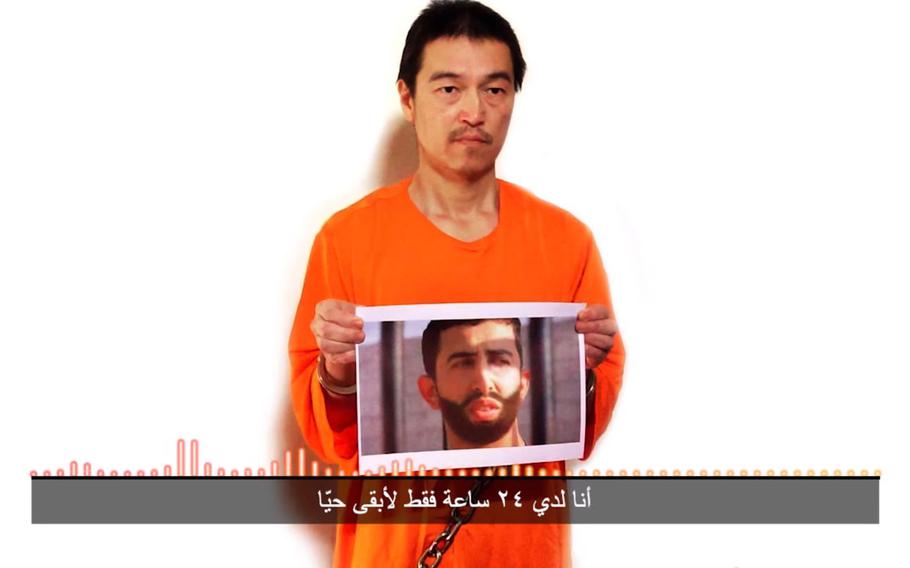 This still image taken from a video posted on YouTube by jihadists on Tuesday, Jan. 27, 2015, shows a still photo of Japanese journalist Kenji Goto holding what appears to be a photo of Jordanian pilot 1st Lt. Mu'ath al-Kaseasbeh. Both are being held hostage by the Islamic State militant group. The still image was overdubbed with audio in which Goto delivers a message from the militants demanding the release of Sajida al-Rishawi, an Iraqi woman sentenced to death in Jordan for involvement in a 2005 terror attack that killed 60 people. The Arabic subtitle reads "I only have 24 hours left to live." The Associated Press could not independently verify the video.