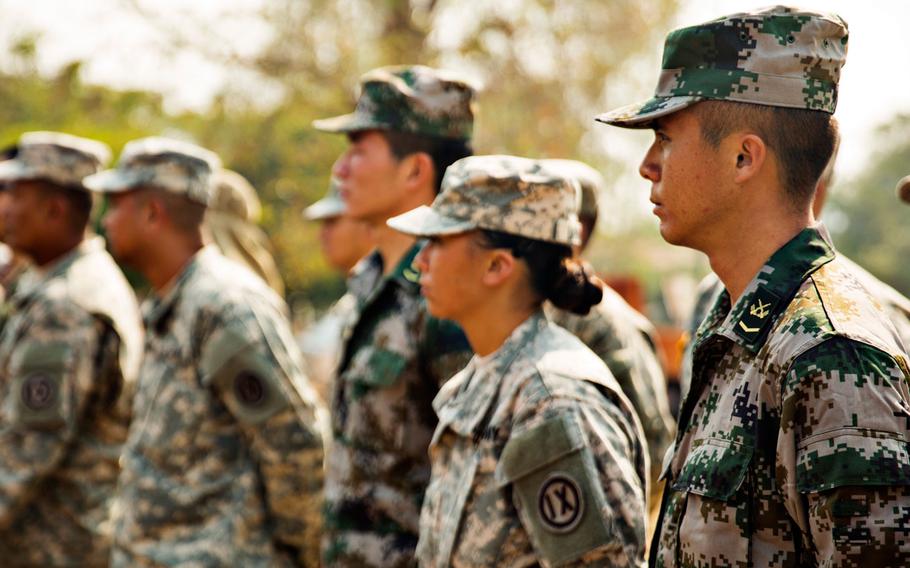 Chinese and U.S. soldiers stand in formation during a ceremony for a new facility at Ban Nhong-Plong Elementary School, located in Chai Badan District, Thailand, Jan. 24, 2015. As part of Exercise Cobra Gold 2015, a combined force of U.S., Chinese and Thai military engineers worked on the building. The structure will serve as a town meeting center and school cafeteria.
