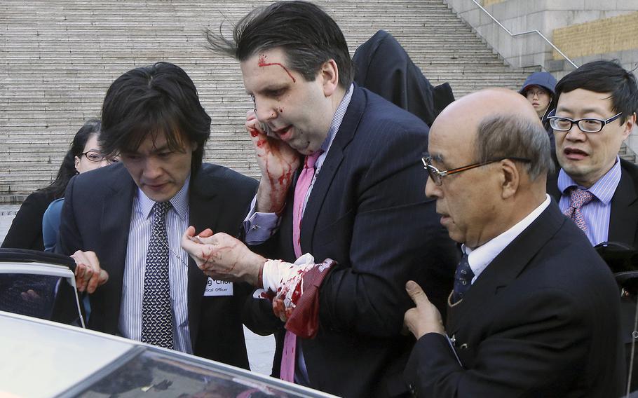 U.S. Ambassador to South Korea Mark Lippert, center, gets into a car to leave for a hospital in Seoul, South Korea, Thursday, March 5, 2015 after a man slashed Lippert on the face and wrist.