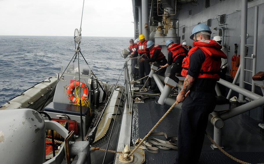 Sailors attached to the U.S. 7th Fleet flagship USS Blue Ridge lower an inflatable boat that will be used to rescue five stranded Philippine fishermen. Blue Ridge is currently on patrol in the Indo-Asian Pacific region. 