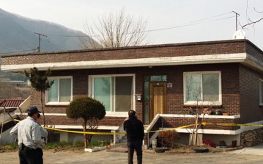Officials investigate the South Korean home where a 105mm training round struck the roof March 29, 2015, after it originated from nearby Rodriguez Range.
