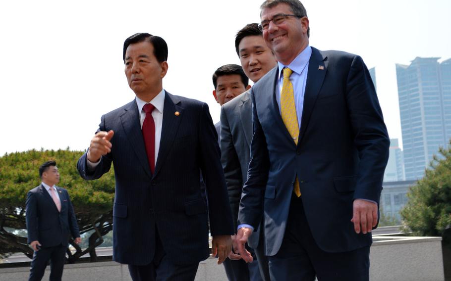 Defense Secretary Ash Carter, right, walks alongside South Korean Defense Minister Han Minkoo for a ceremonial guard review at the Ministry of National Defense on Friday, April 10, 2015. Carter had met with the South Korean president in Seoul earlier in the day.