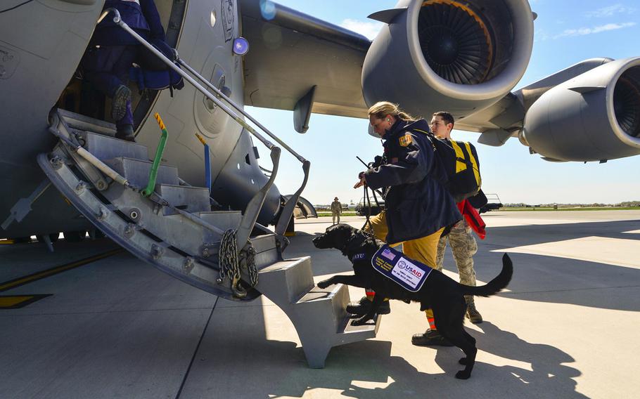 Jennifer Massey, Fairfax County Urban Search and Rescue K-9 search specialist, Fairfax, Va., and her K-9, Phayu, board a U.S. Air Force C-17 Globemaster III at Dover Air Force Base, Del., April 26, 2015. Massey and Phayu are part of a 69-person search and rescue team deploying to Nepal to assist in rescue operations after the country was struck by a 7.8-magnitude earthquake.