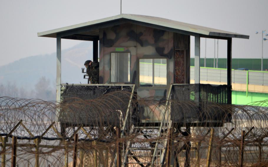 South Korean soldiers stand guard near the Han River north of Seoul in April 2013. Posts, bunkers and double barbwire fences are common site along Korean National Route Number 77, near the DMZ. South Kore says it will replace portions of a 16.4-mile stretch of barbed wire along the northeast coast with electronic surveillance equipment after residents complained the fence is ugly.