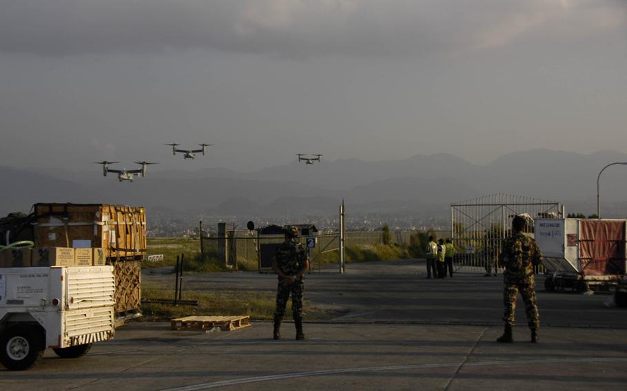 Nepalese soldiers watch V-22 Osprey tilt-rotor aircraft arrive in Nepal's capital, Kathmandu on Sunday, May 3, 2015, to aid in the earthquake relief effort. 

              