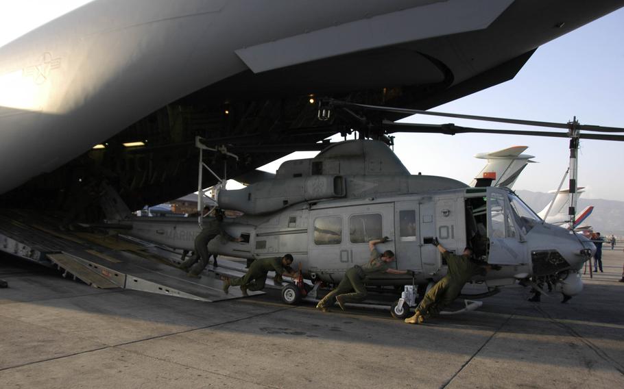 Marines unload a UH-1 Huey helicopter from an Air Force C-17 transport plane at Kathmandu, Nepal, Sunday, May 3, 2015. 
