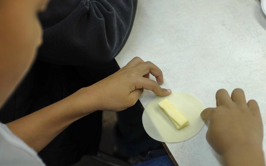 Alexander Richardson, a second grader from Joan K. Mendel Elementary School in Yokota Air Base, Japan, makes a cheese "gyouza," or dumpling, May 5, 2015 during the school's annual cultural festival, JapANDasia at Yokota Air Base, Japan. More than 160 volunteers participated in the festival to teach the elementary school students about Japanese culture and language.