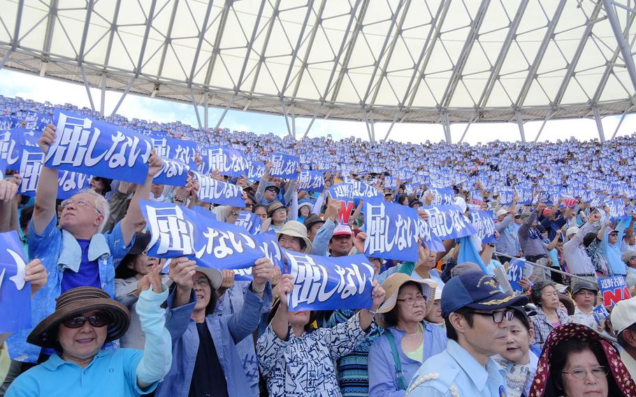 Protesters against a new runway at Camp Schwab in Okinawa, Japan, hold a sign that says "We will never give up," Sunday, May 17, 2015. Some 35,000 people gathered for the rally at a baseball stadium in Naha, Japan. 


