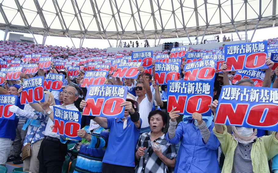 Protesters hold signs that read "No to a new military base at Henoko" during a protest rally Sunday, May 17, 2015, at the Okinawa Cellular Stadium in Japan. According to organizers, about 35,000 people from throughout the country gathered for the event.

