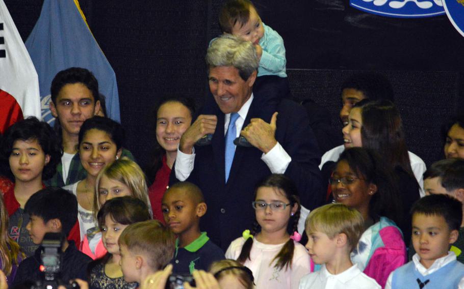 A baby sitting on Secretary of State John Kerry’s shoulders clutches the secretary’s hair at Yongsan Garrison’s Collier Field House on Monday, May 18, 2015. Kerry posed for photos after giving remarks to a crowd of about 400. 

