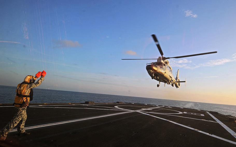 A Dolphin Z-9 helicopter from China's Navy missile frigate CNS Yulin flies off the deck of Singapore's Navy missile frigate RSS Intrepid May 25, 2015, during Exercise Maritime Cooperation 2015 in the South China Sea near Singapore.  