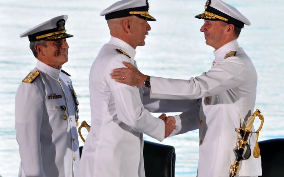 Adm. Jonathan W. Greenert, right, chief of naval operations, shakes the hand of Adm. Scott H. Swift, who assumed command of the U.S. Pacific Fleet during a ceremony at Joint Base Pearl Harbor-Hickam, Hawaii, on Wednesday, May 27, 2015. Adm. Harry B. Harris Jr., who watches from left, assumed command of U.S. Pacific Command at the same ceremony.
