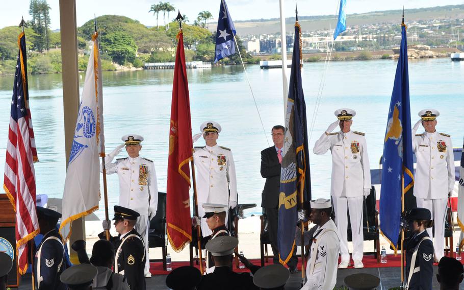 Defense and military officials stand for the national anthem during a change-of-command ceremony Wednesday, May 27, 2015, at Joint Base Pearl Harbor-Hickam, Hawaii. From left are incoming U.S. Pacific commander Adm. Harry B. Harris, Jr.,; Adm. Jonathan W. Greenert, chief of naval operations; Ash Carter, secretary of defense; Samuel J. Locklear, III, retiring PACOM commander; and Adm. Scott H. Swift, incoming commander of U.S. Pacific Fleet.