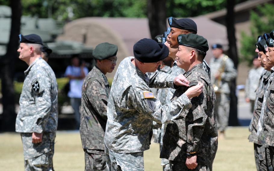 Col. Michael F. Pappal, the 2nd Infantry Division's chief of staff, places a Combined Division tab on a South Korean officer Wednesday at an activation ceremony at Camp Red Cloud, in Uijeongbu, for the new Combined Division. 

