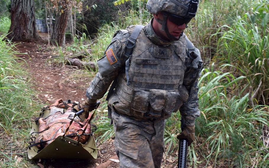 A soldier drags a mock casualty in a test of his first-aid skills while in combat conditions as part of the Best Warrior Challenge in Hawaii on June 9, 2015.