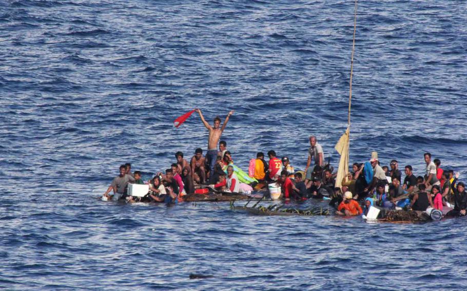 A group of 65 people floats on a bamboo raft in the Makassar Strait, off Indonesia, while crewmembers aboard the amphibious dock landing ship USS Rushmore prepare a rescue on June 10, 2015. 

