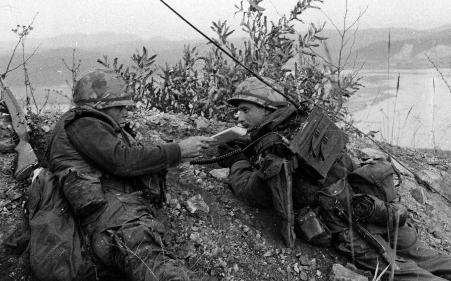 After taking possession of a hill during an operational readiness test in South Korea, 2nd Lt. George Baker, left, of Company A, 1st Battalion, 9th Infantry Regiment, uses a radio carried by Pfc. Donald Linkovic to keep in contact with battalion headquarters on Dec. 7, 1967.