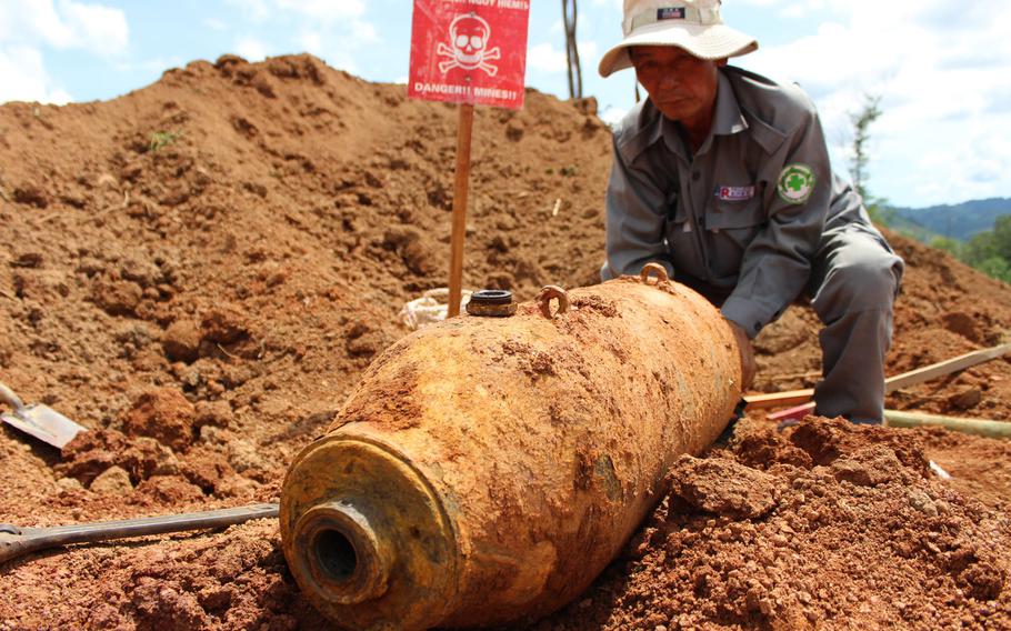 A technician with Project Renew prepares a 250-pound aerial bomb for transport and destruction Friday, June 20, 2015, in central Vietnam. It is one of a vast number of unexploded ordnance left over from the Vietnam War.