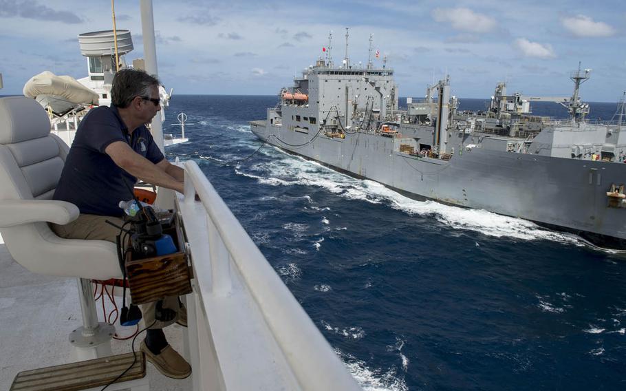 Capt. Thomas Giudice, master of hospital ship USNS Mercy, watches as USNS Washington Chambers transfers fuel during a replenishment at sea Friday during Pacific Partnership 2015. Mercy received dry goods, frozen and fresh foods, medical supplies and 12,000 barrels of fuel.