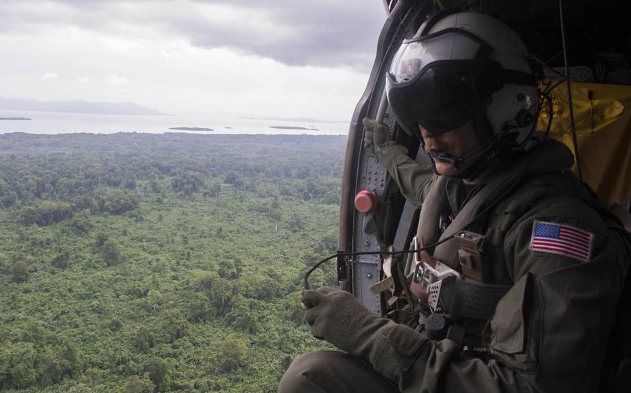 Naval Aircrewman 2nd Class Tedd Allen of Helicopter Sea Combat Squadron 21 looks out the window of an MH-60S Seahawk as he flies a mission from the hospital ship USNS Mercy on Friday in support of Pacific Partnership 2015. Mercy is in Papua New Guinea for its second mission port of Pacific Partnership, the largest annual multilateral humanitarian assistance and disaster relief preparedness mission conducted in the Indo-Asia-Pacific region. 