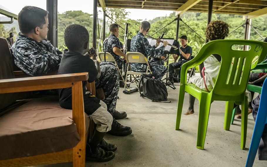 Musician 1st Class Brandon Barbee and a Papua New Guinea children watch a woodwind quintet perform Sunday during Pacific Partnership 2015. During its seven days in Arawa, Mercy's crew will provide medical and dental services, help make improvements to community school buildings, and host engagements focusing on women's health and violence prevention.