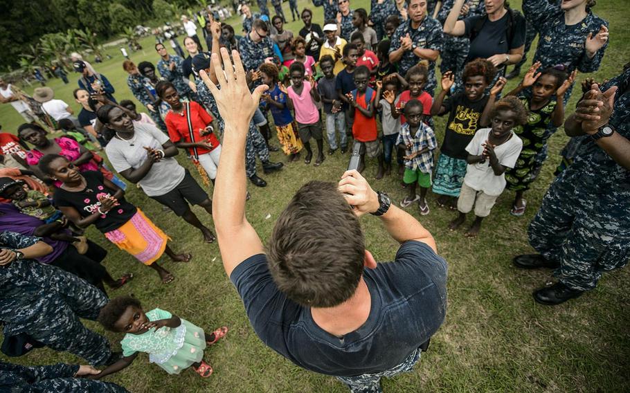 Musician 3rd Class Steve Lamonica interacts with a crowd while performing Sunday during Pacific Partnership 2015 in Arawa, Papua New Guinea. During its seven days in Arawa, Mercy's crew will provide medical and dental services, help make improvements to community school buildings, and host engagements focusing on women's health and violence prevention.