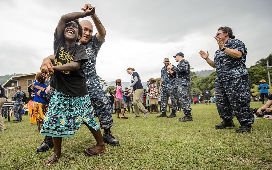 Master-at-Arms Chief Rodrigo Celones dances with a Papua New Guinea girl Sunday during Pacific Partnership 2015 in Arawa, Papua New Guinea. Mercy, carrying 900 personnel from the United States, Japan, Australia, New Zealand and Timor Leste, is scheduled to be in Arawa through July 3 and then move on to Rabaul, Papua New Guinea. The ship, which has already completed a visit to Fiji, will also make stops in the Philippines and Vietnam.