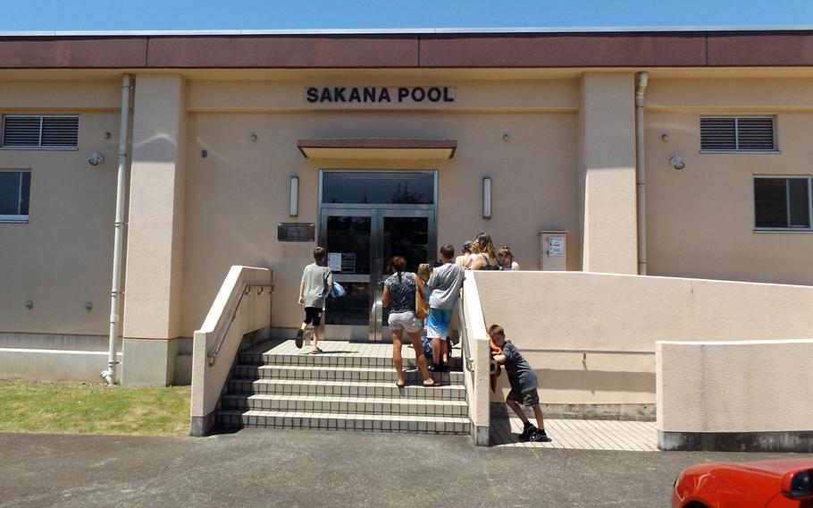 Families form a line to enter the Sakana Pool on Yokota Air Base on July 14, 2015.