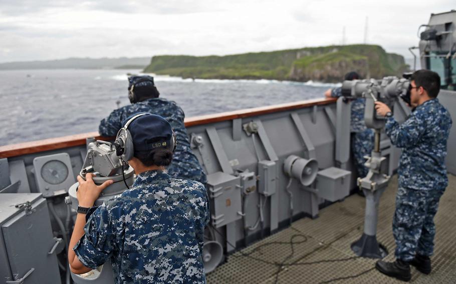 Sailors look for surface contacts as the amphibious dock landing ship USS Ashland pulls into Naval Base Guam on Aug. 3, 2015.