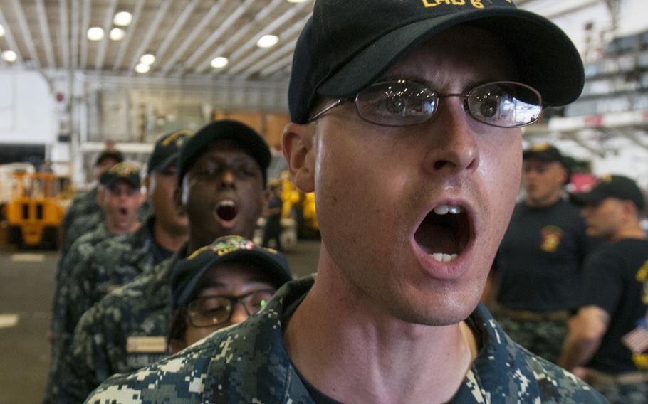 Chief selectees sing ''Anchors Aweigh'' during a rehearsal for the chief pinning ceremony Sept. 15, 2015, in the hangar bay of the USS Bonhomme Richard at Sasebo Naval Base, Japan. 