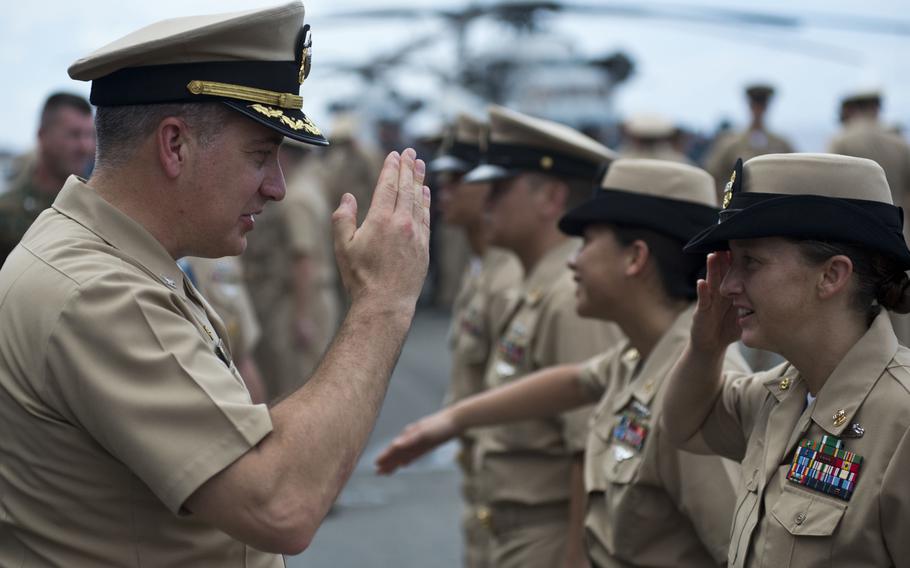 Capt. Daniel Dusek, commander of the USS Bonhomme Richard, salutes newly pinned Chief Petty Officer Racheal F. Peebles during a chief pinning ceremony held on the Bonhomme's flight deck at Sasebo Naval Base, Japan, on Sept. 15, 2015.