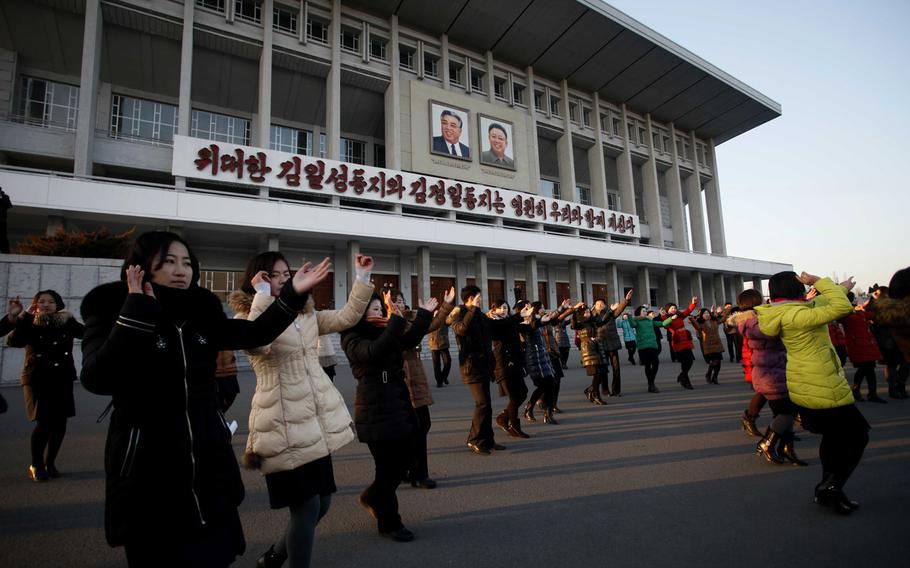 People dance near the Pyongyang Indoor Stadium in Pyongyang, North Korea, Friday, Jan. 8, 2016, after the government said it had conducted a hydrogen bomb test two days earlier. 