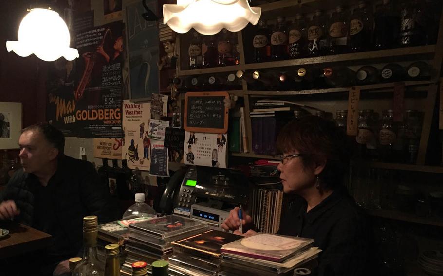 La Jetee owner Tomoyo Kawai, right, speaks French with customers in Tokyo's Golden Gai district. She has been running the tiny bar, which counts foreign filmmakers such as Francis Ford Coppola and Quentin Tarantino as customers, since 1974.