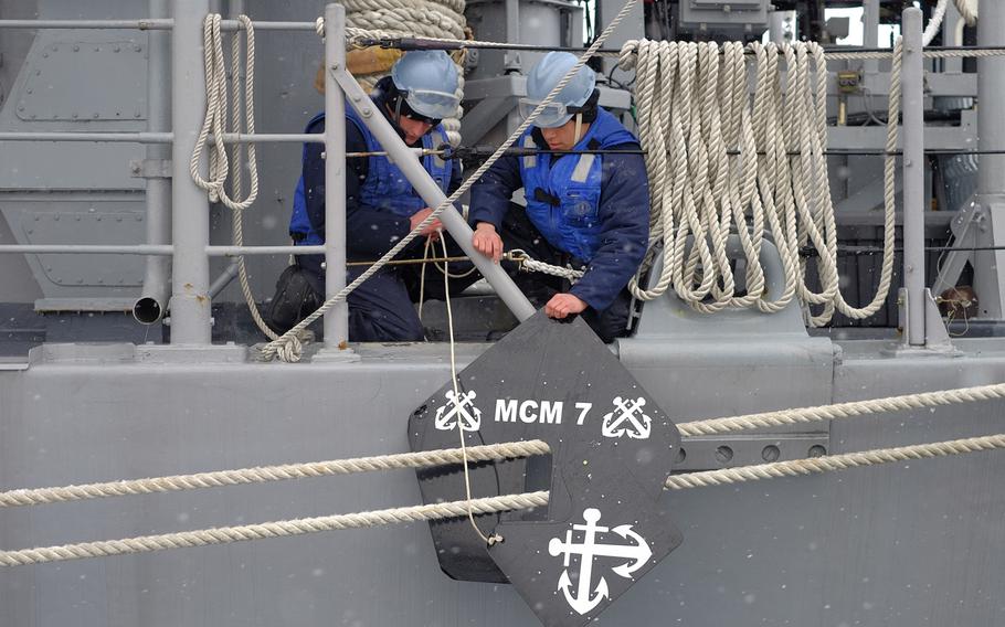 Crewmembers place rat guards on the mooring lines tying USS Patriot to the pier in Otaru, Japan, on Thursday, Feb. 4, 2016. 

