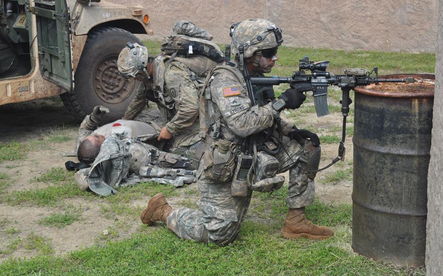 A soldier keeps watch as another tends to a casualty during a mock raid on a terrorist stronghold during Exercise Lightning Forge Feb. 5, 2016, at Marine Corps Training Area Bellows.

Wyatt olson
Stars and Stripes