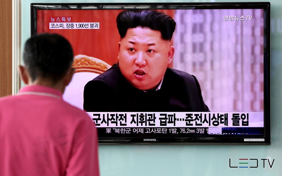 A man looks at a television screen showing an image of Kim Jong Un, leader of North Korea, during a news broadcast on North Korea's exchange of fire with South Korea in August, 2016.