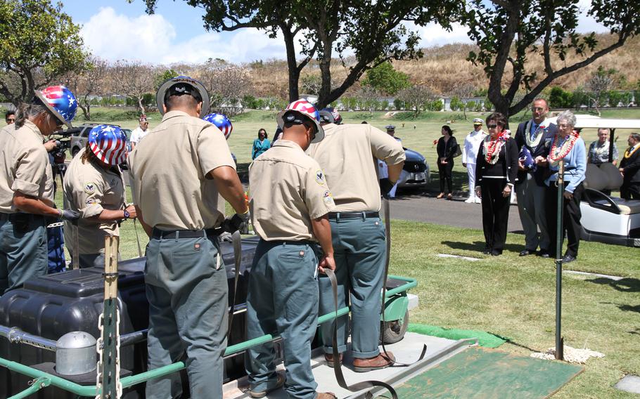 Family members watch as the casket of Petty Officer 1st Class Vernon T. Luke, a  USS Oklahoma crew member, is lowered into his grave March 9, 2016, at the National Memorial Cemetery of the Pacific in Honolulu.