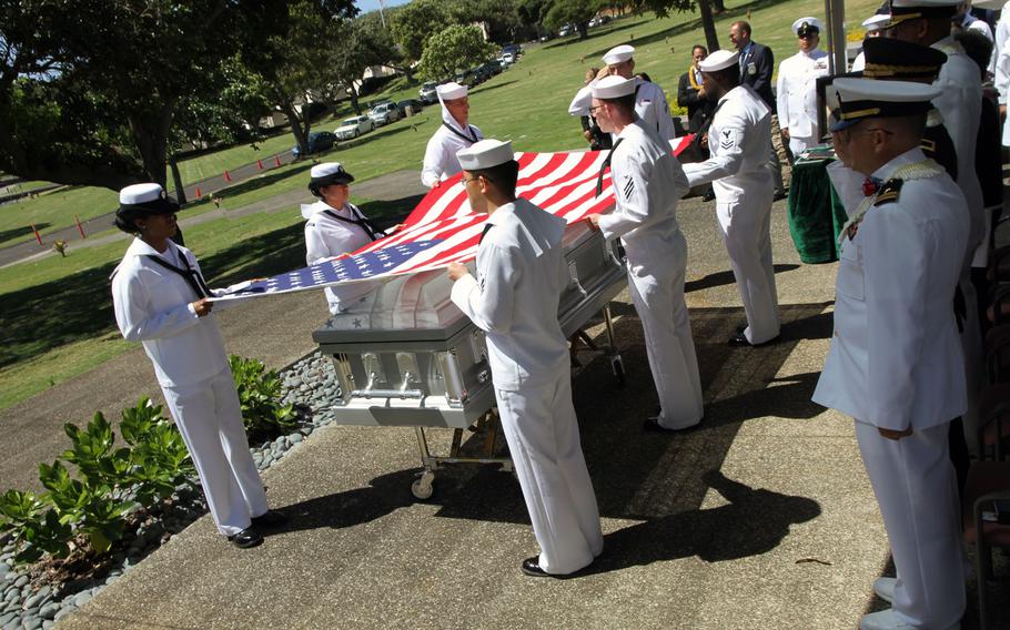 Sailors prepare to fold the American flag that was draped over the casket of Petty Officer 1st Class Vernon T. Luke, a  USS Oklahoma crew member, during a funeral held March 9, 2016, at the National Memorial Cemetery of the Pacific in Honolulu.