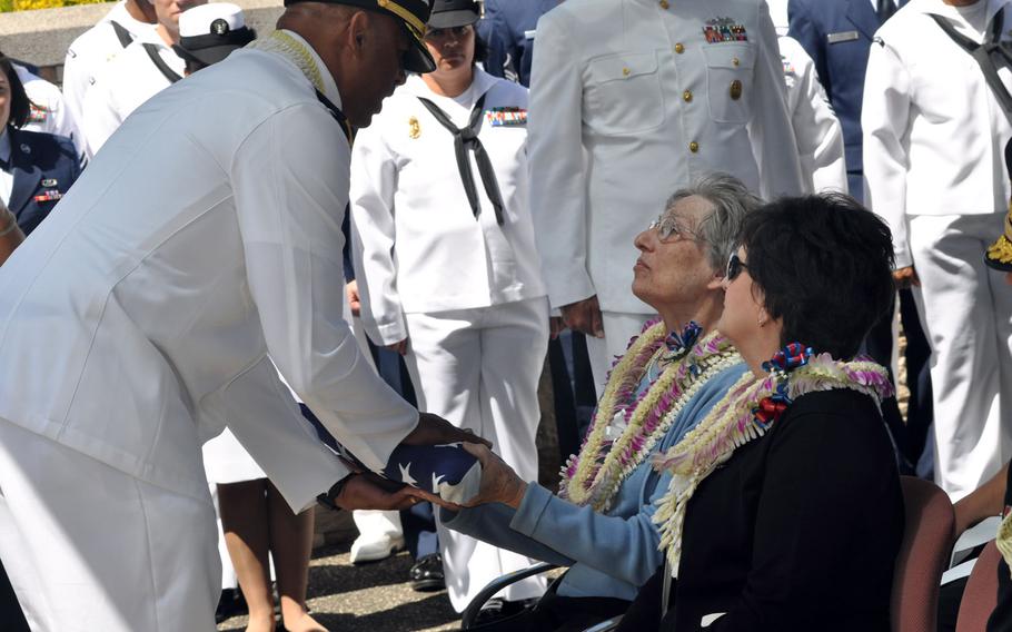 Rear Adm. John V. Fuller, commander of Navy Region Hawaii, presents the casket flag of Petty Officer 1st Class Vernon T. Luke to his niece, Leeann Michalske, during a funeral at the National Memorial Cemetery of the Pacific in Honolulu, March 9, 2016.