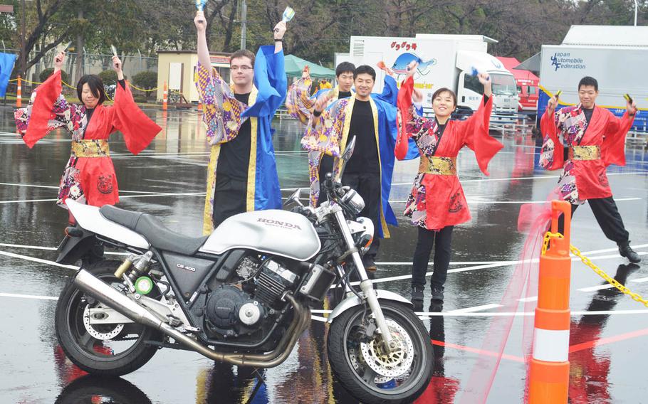U.S. and Japanese servicemembers dance to celebrate the opening of a motorcycle training range Friday, March 11, 2016, at Yokota Air Base in western Tokyo.