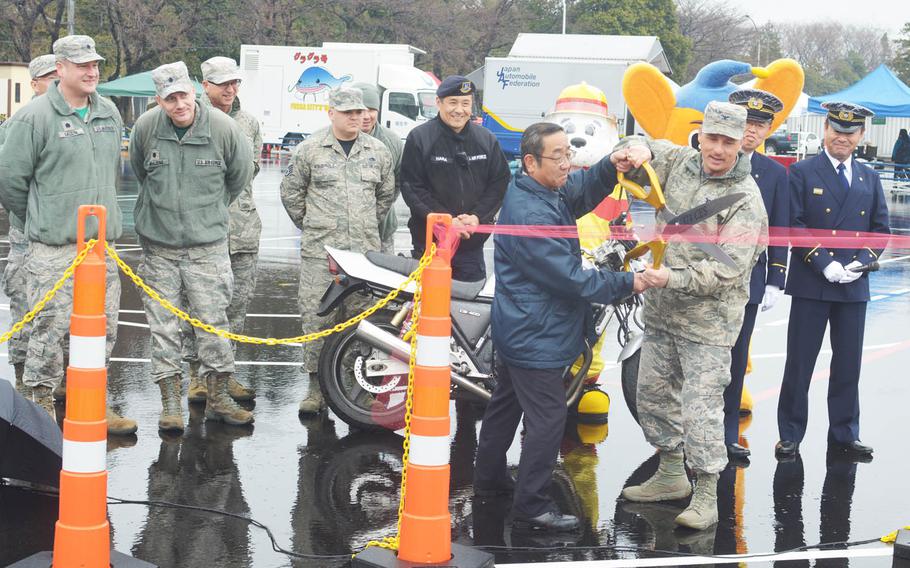 Yokota deputy occupational safety manager Masaharu Kawagishi and 374th Mission Support Group commander Col. Scott Maskery cut a ribbon to open a new motorcycle training range at the western Tokyo air base, Friday, March 11, 2016.