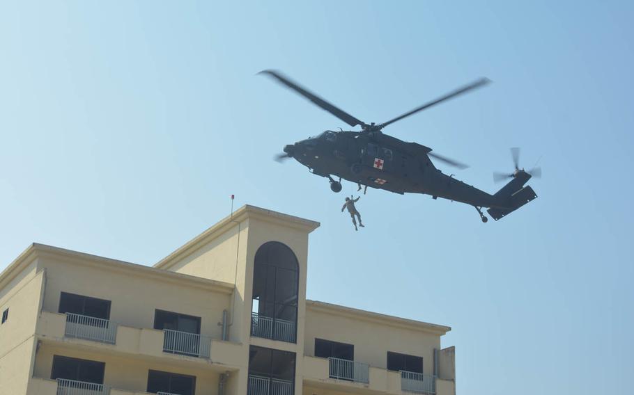 A U.S. soldier rides a hoist from the roof of a high-rise building into a hovering Black Hawk helicopter at Rodriguez Live Fire Range, a training area in South Korea near the Demilitarized Zone, Wednesday, March 16, 2016.