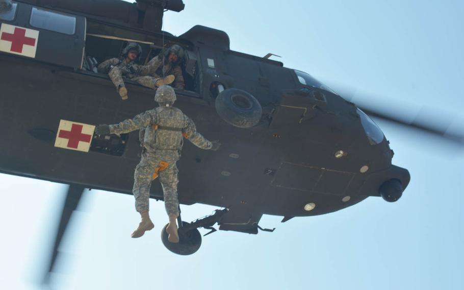 A U.S. soldier rides a hoist into a hovering Black Hawk helicopter at Rodriguez Live Fire Range, a training area in South Korea near the Demilitarized Zone, Wednesday, March 16, 2016.