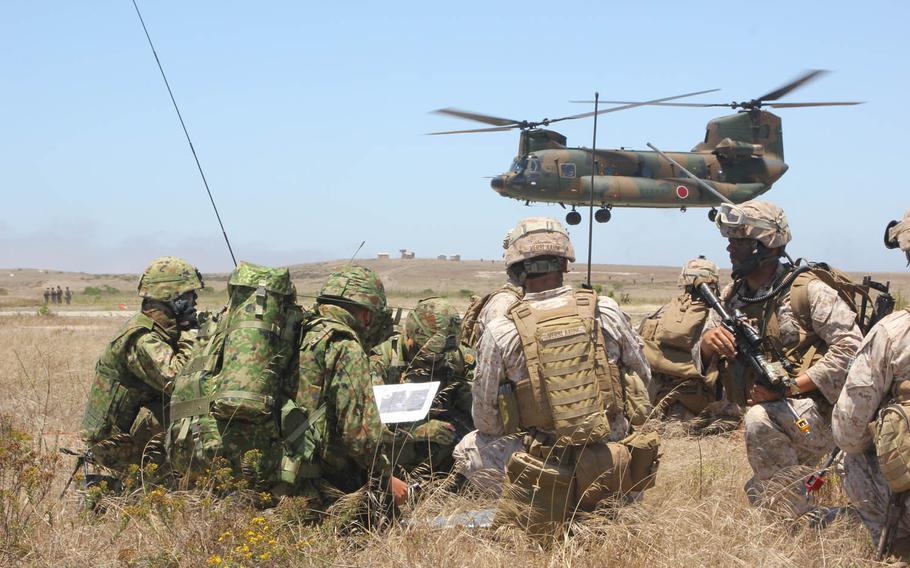 U.S. Marines and Japanese Self-Defense Force soldiers go over maneuver tactics while conducting amphibious assault operations on San Clemente Island, June 17, 2013. Laws that would allow Japanese forces to defend its close allies if under attack will take effect March 29, 2016.