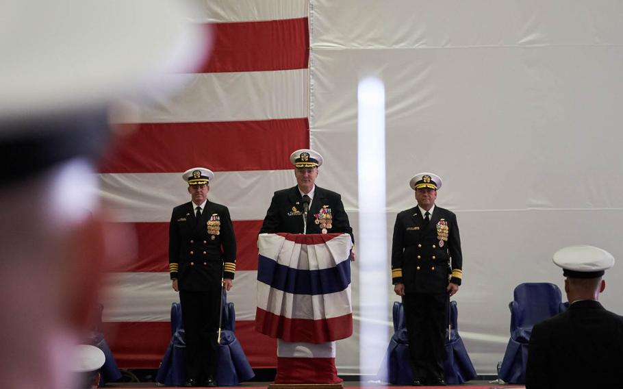 Capt. Chris Bolt reads his new military assignment orders moments before passing command of the USS Ronald Reagan to Capt. Michael Donnelly, left, at a change-of-command ceremony at Yokosuka Naval Base, Japan, Tuesday, April 12, 2016. 