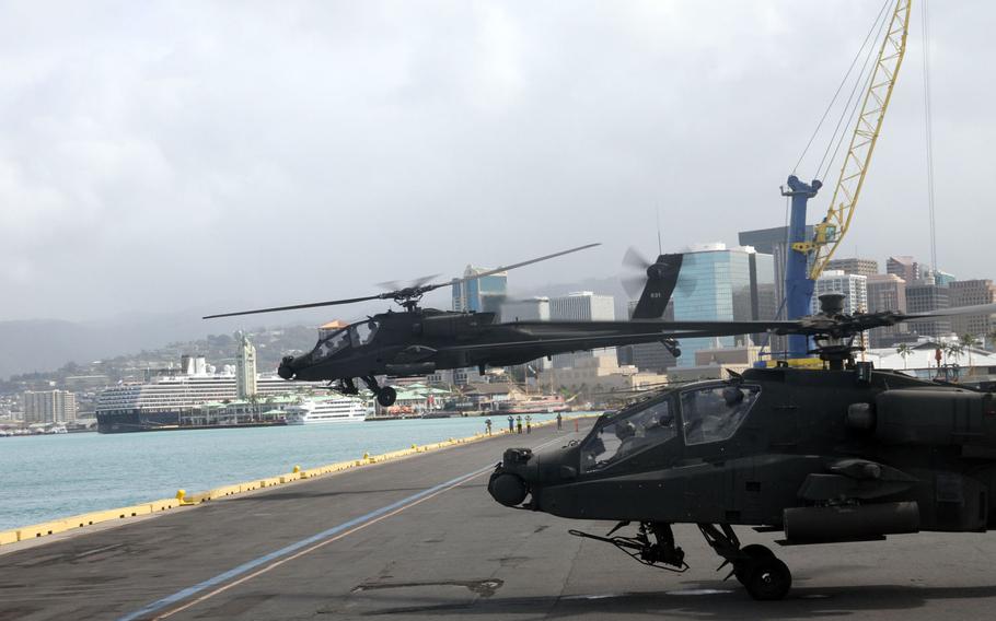 An Apache attack helicopter lifts off from a commercial port near downtown Honolulu, Hawaii, Sunday April 24, 2016. Twenty-four Apaches were transitioned from units in five states, grouped in California, then shipped from San Diego.