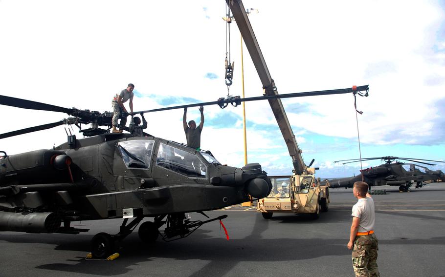 A maintenance crew readies a propeller on an Apache attack helicopter Sunday, April 24, 2016, in Honolulu, Hawaii. Two dozen Apaches are in Hawaii as part of the Army’s two-year aviation restructuring of the 25th Infantry Division.