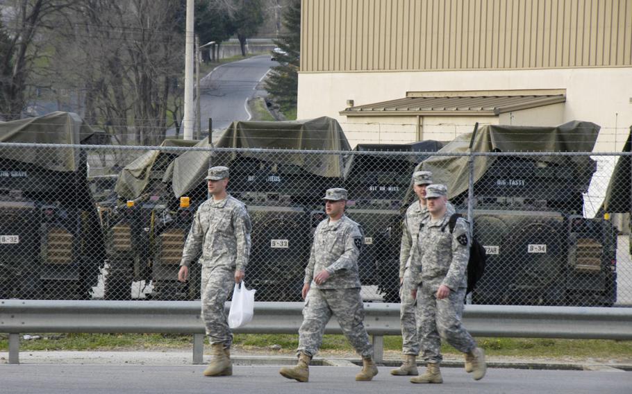Soldiers from the 2nd Infantry Division walk past tactical vehicles at Camp Casey, South Korea.